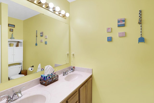 bathroom featuring a sink, toilet, and double vanity