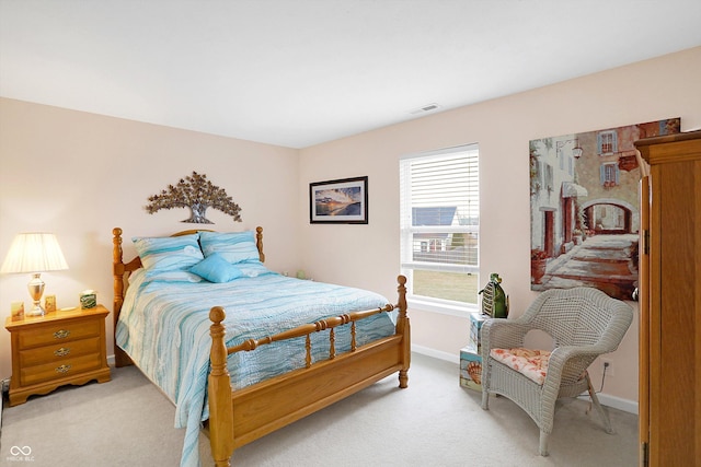 bedroom with baseboards, light carpet, and visible vents