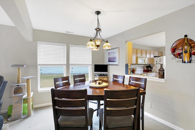 dining area with visible vents, light carpet, baseboards, and a chandelier