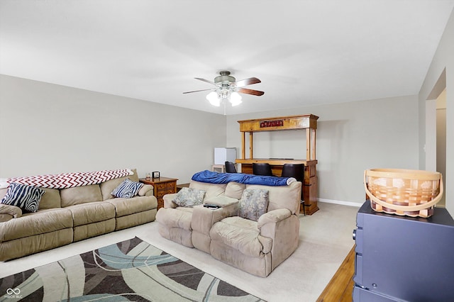 bedroom with a ceiling fan, baseboards, and light carpet