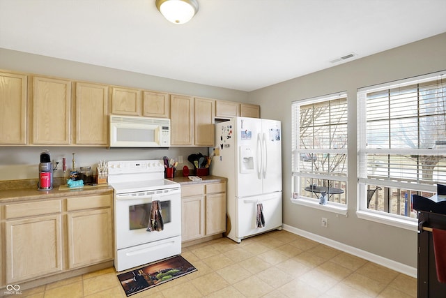 kitchen featuring visible vents, light brown cabinetry, white appliances, light countertops, and baseboards