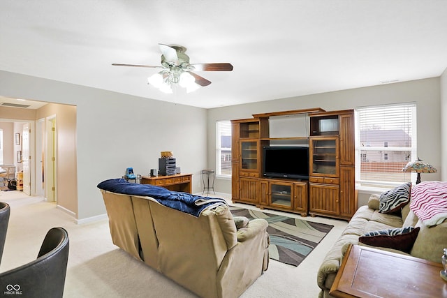 living room featuring visible vents, light carpet, plenty of natural light, and a ceiling fan