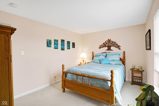 bedroom with baseboards and light colored carpet