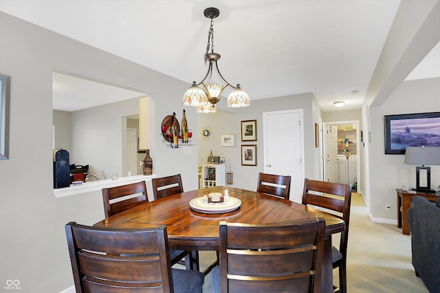 dining space with baseboards, independent washer and dryer, and light carpet