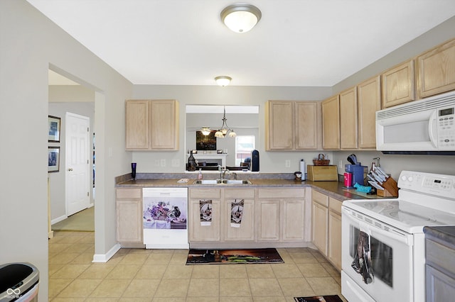 kitchen featuring baseboards, light brown cabinetry, light tile patterned floors, white appliances, and a sink