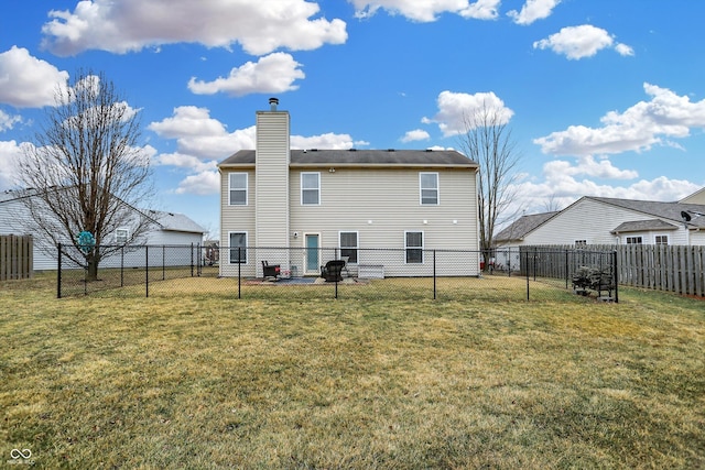 rear view of property with a lawn, a chimney, and fence