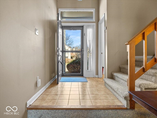 foyer with baseboards, stairs, and tile patterned flooring