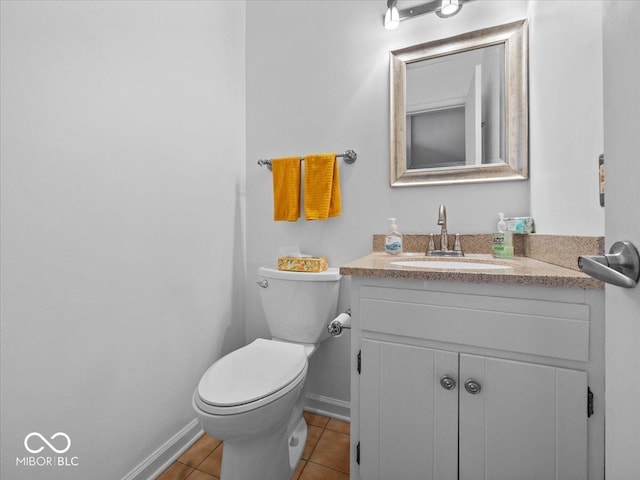 bathroom with baseboards, toilet, vanity, and tile patterned flooring