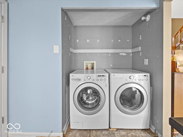 laundry room with laundry area, separate washer and dryer, baseboards, and a textured ceiling