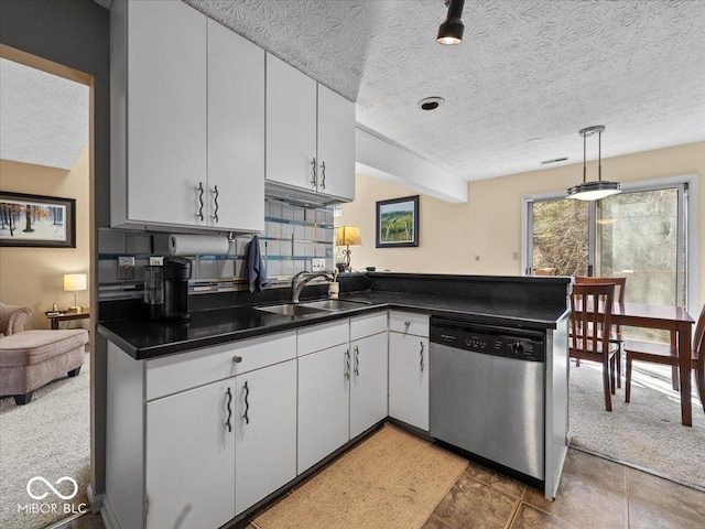 kitchen with a sink, tasteful backsplash, dark countertops, white cabinets, and dishwasher