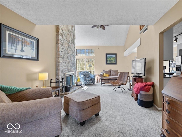 carpeted living area featuring a stone fireplace, vaulted ceiling, and a textured ceiling