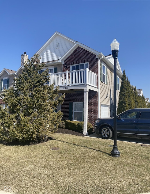 exterior space featuring a yard, brick siding, and an attached garage