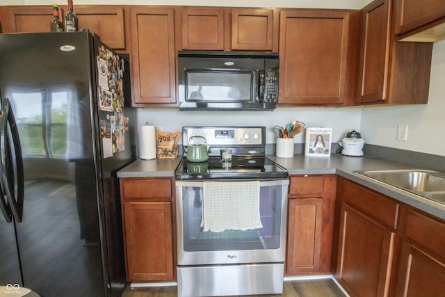 12145 Bubbling Brook Dr Unit 600, Fishers, IN 46038 - kitchen featuring black appliances, brown cabinetry, and dark countertops