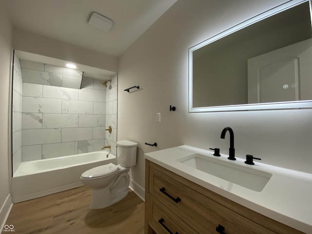 bathroom with toilet, shower / tub combination, wood finished floors, baseboards, and vanity