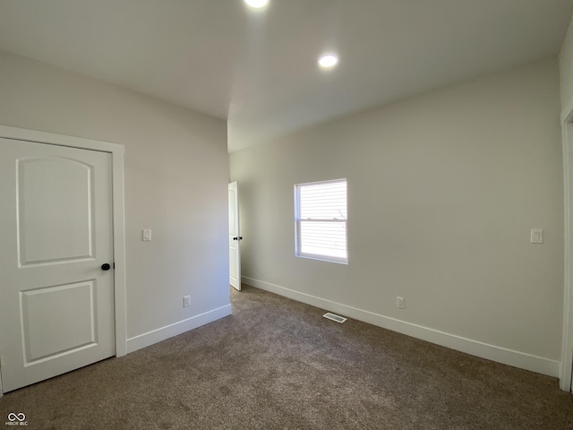 spare room featuring visible vents, recessed lighting, baseboards, and dark colored carpet