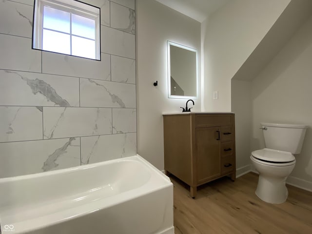 full bathroom featuring vanity, toilet, wood finished floors, and a washtub