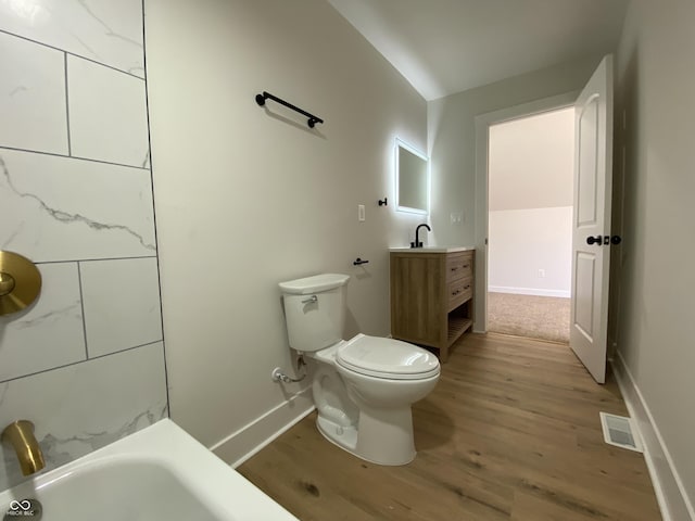 full bathroom with vanity, wood finished floors, a bathing tub, visible vents, and toilet