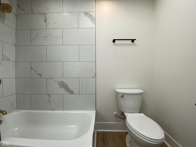 bathroom featuring shower / washtub combination, toilet, baseboards, and wood finished floors