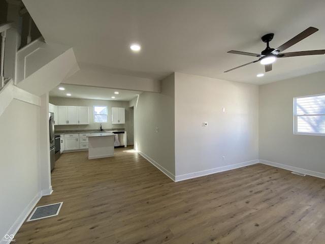 kitchen featuring wood finished floors, visible vents, recessed lighting, white cabinetry, and open floor plan