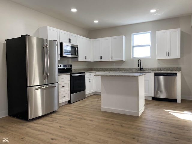 kitchen featuring stainless steel appliances, light wood-style floors, and white cabinetry