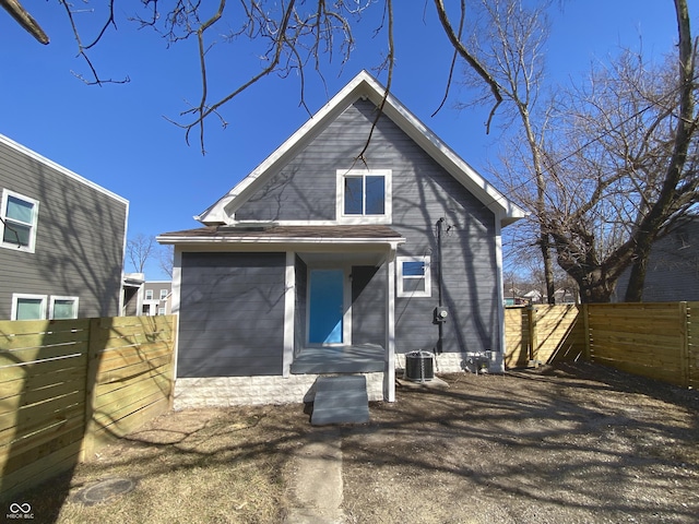 rear view of house with central AC unit and fence