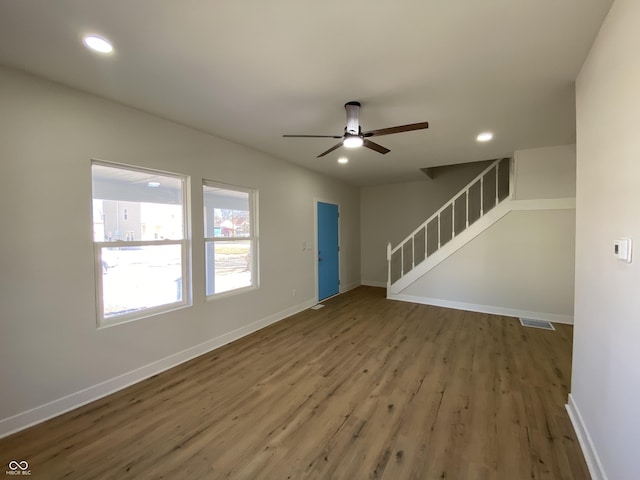 unfurnished living room with stairway, recessed lighting, visible vents, and baseboards