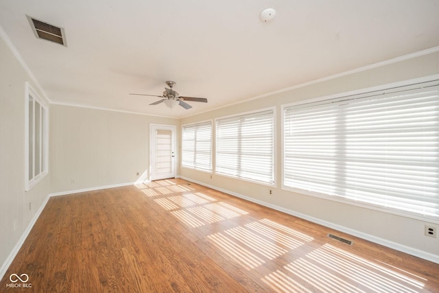 spare room featuring visible vents, ornamental molding, and light wood finished floors