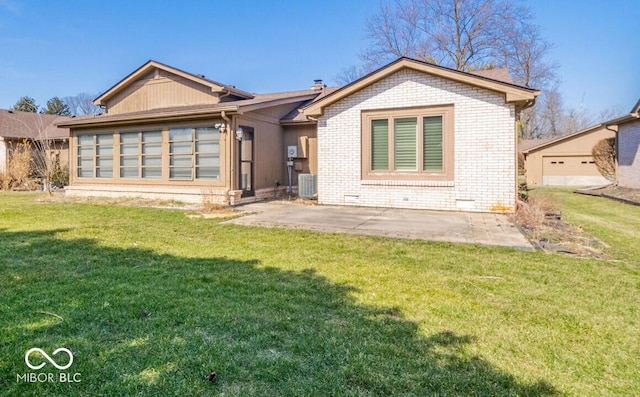 rear view of property with brick siding, central AC, a lawn, a chimney, and a patio