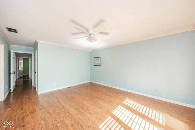 unfurnished room featuring visible vents, a ceiling fan, wood finished floors, crown molding, and baseboards