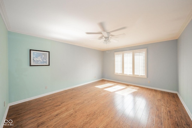 unfurnished room featuring baseboards, crown molding, a ceiling fan, and wood finished floors