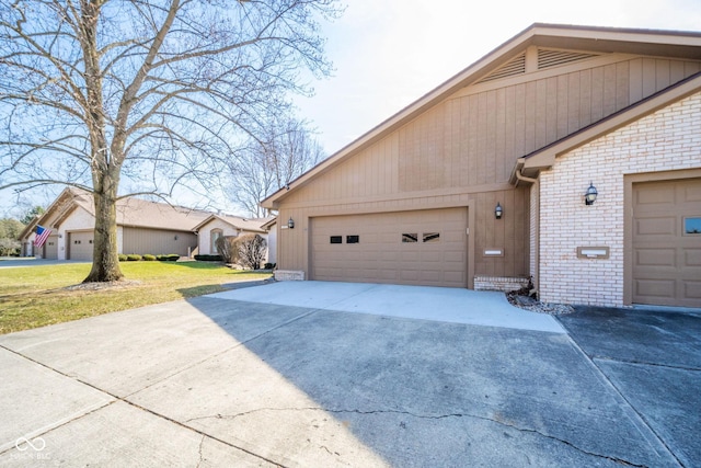 view of side of property featuring a yard, brick siding, concrete driveway, and an attached garage