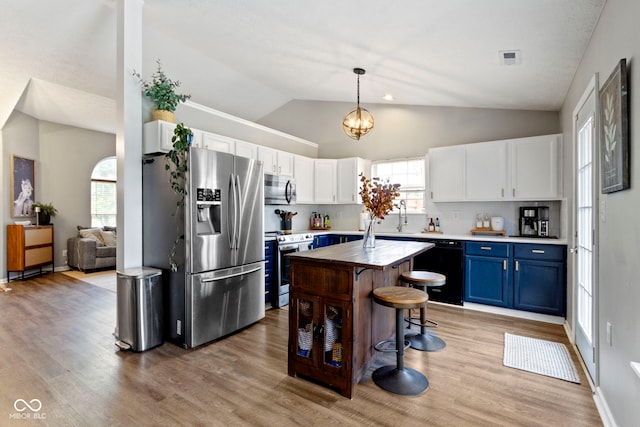 12612 Clearview Ln, Indianapolis, IN 46236 - kitchen featuring stainless steel appliances, blue cabinets, vaulted ceiling, light countertops, and white cabinets