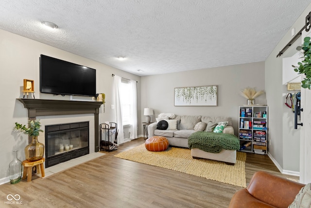 12612 Clearview Ln, Indianapolis, IN 46236 - living area featuring a textured ceiling, wood finished floors, a fireplace with flush hearth, and baseboards