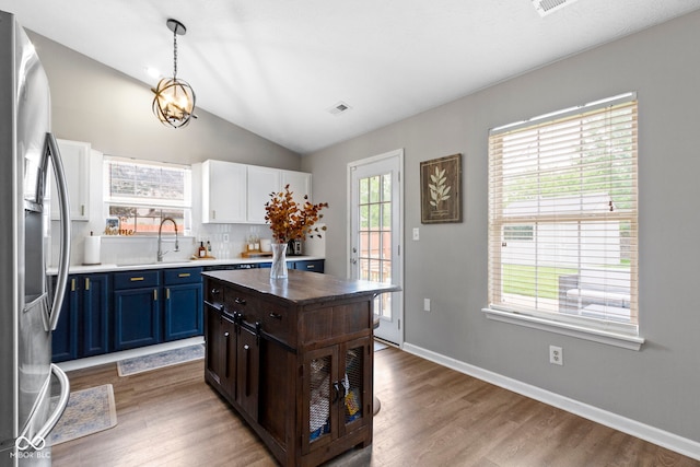 12612 Clearview Ln, Indianapolis, IN 46236 - kitchen featuring a sink, stainless steel fridge, blue cabinetry, light wood-type flooring, and vaulted ceiling