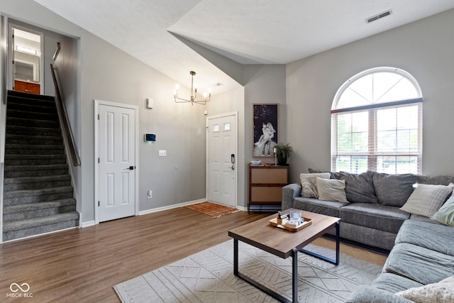 12612 Clearview Ln, Indianapolis, IN 46236 - living room featuring a chandelier, stairs, vaulted ceiling, wood finished floors, and baseboards