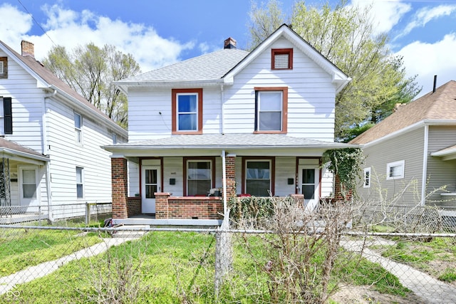 view of front of property with covered porch, a chimney, a shingled roof, a fenced front yard, and brick siding