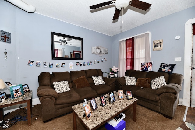 living room with a ceiling fan and a textured ceiling