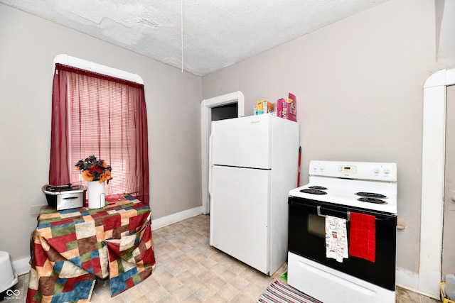 kitchen with baseboards, white appliances, and a textured ceiling