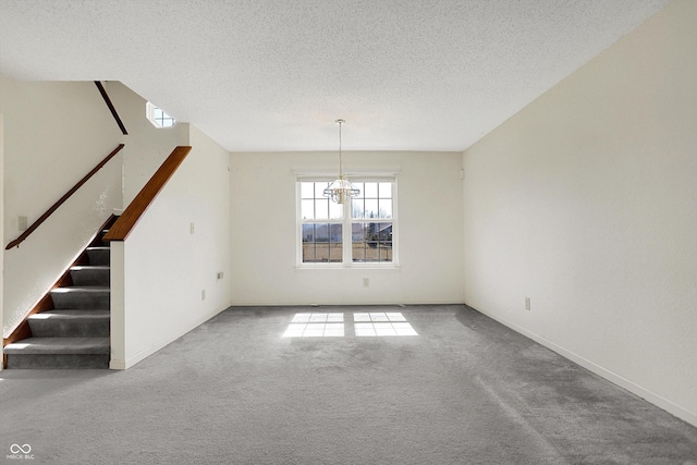 interior space featuring baseboards, carpet, stairway, a notable chandelier, and a textured ceiling