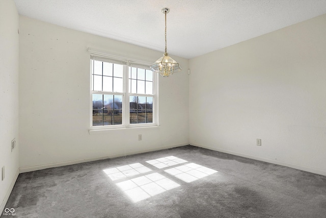 unfurnished room with a chandelier, baseboards, a textured ceiling, and carpet