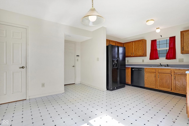 kitchen featuring light floors, dishwasher, light countertops, black refrigerator with ice dispenser, and a sink