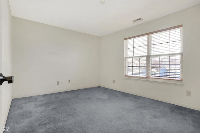 carpeted spare room with baseboards and visible vents