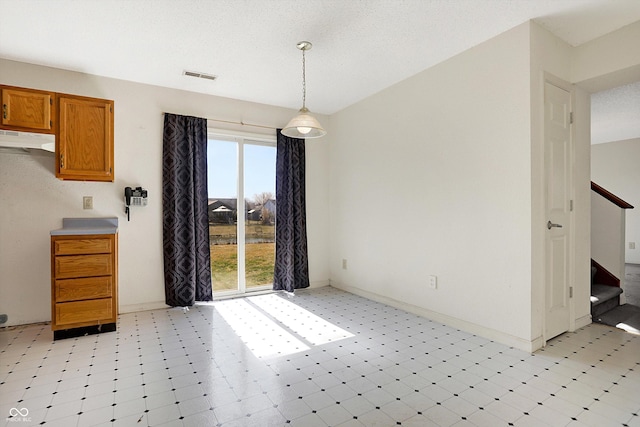 unfurnished dining area with visible vents, baseboards, light floors, and stairway