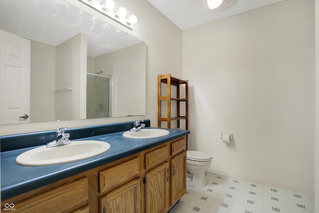 bathroom with a sink, toilet, double vanity, and a shower stall