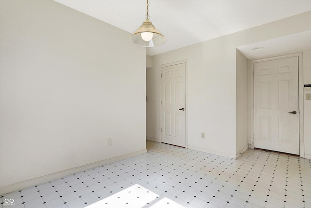 empty room featuring baseboards and light floors