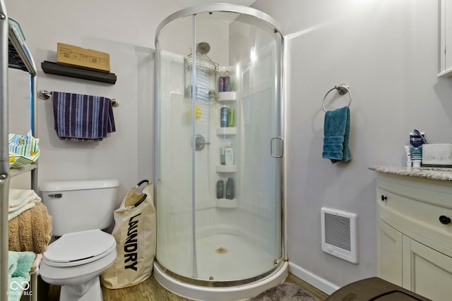 full bathroom with vanity, a stall shower, and wood finished floors