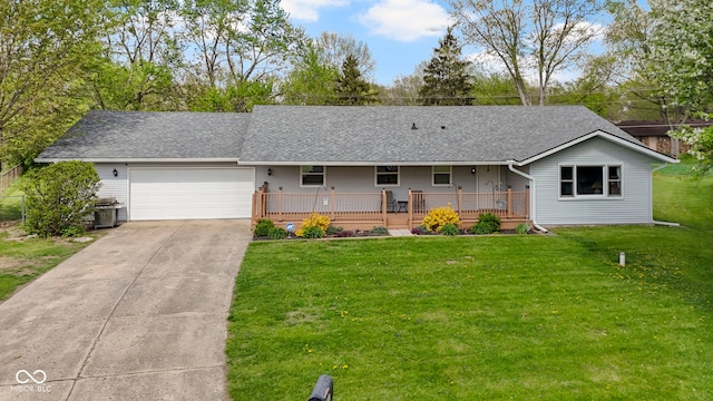 ranch-style house featuring concrete driveway, an attached garage, roof with shingles, and a front lawn