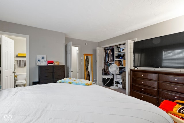bedroom with ensuite bathroom and a closet