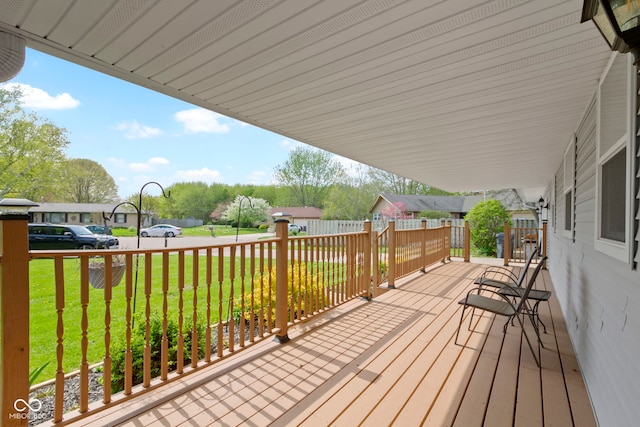wooden deck with a lawn and a residential view