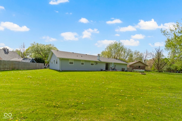 back of house featuring a yard and fence
